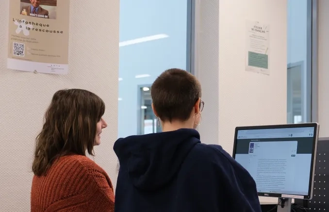 Deux personnes qui regardent un ordinateur 