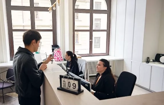Un étudiant s'adresse à une personne à la réception
